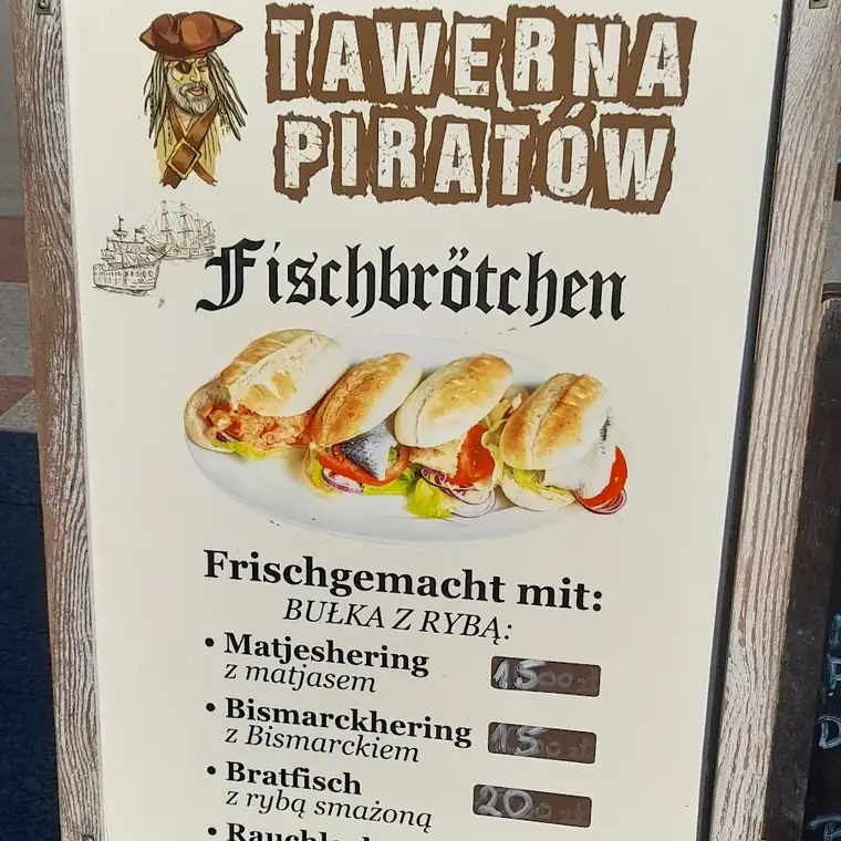 Tablica Tawerna Piratów z bułkami z rybą przed wejściem